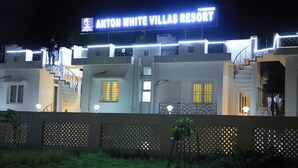 A hotel named Anton White Villas Resort with a signboard, multiple floors, and a staircase. - Anton White Villas Resort (Mahabalipuram)