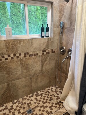 Een douche, handdoeken, zeep, toiletpapier