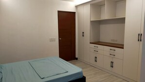 Un dormitori amb llit, armari i zona d'escriptori.