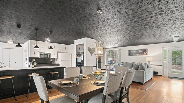 A modern kitchen with white cabinets, a central island, and pendant lighting. - Secluded PoolHouse Estate (College Park)