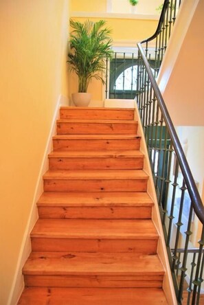 A wooden staircase with a metal railing, leading to an upper floor. - Contador Mor Rooms and Apartments (Lisbon)