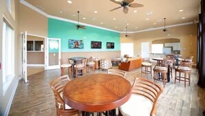 A spacious dining area with multiple round tables and chairs, ceiling fans, and recessed lighting. - Bella Vida Resort Home in Kissimmee (Kissimmee)
