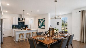 A modern kitchen with white cabinets, a herringbone backsplash, and pendant lighting. - Madmen Loft w/ Uptown Rooftop Views (Charlotte)