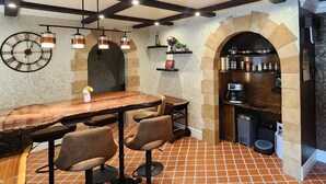 Una cucina rustica con travi a vista, un bancone in legno e un arco in pietra.