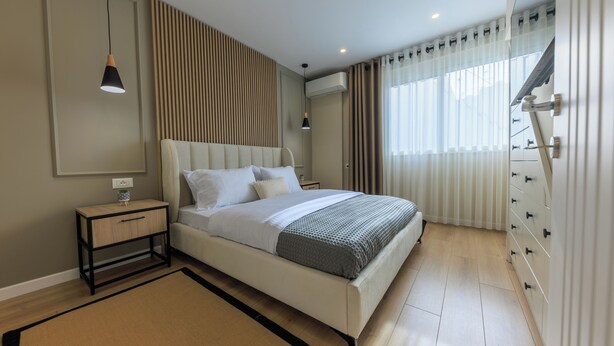 A modern bedroom with a bed, bedside tables, a nightstand, a dresser, and a window with curtains. - Syncron Rooftop City Centre Tirana (Tirana)