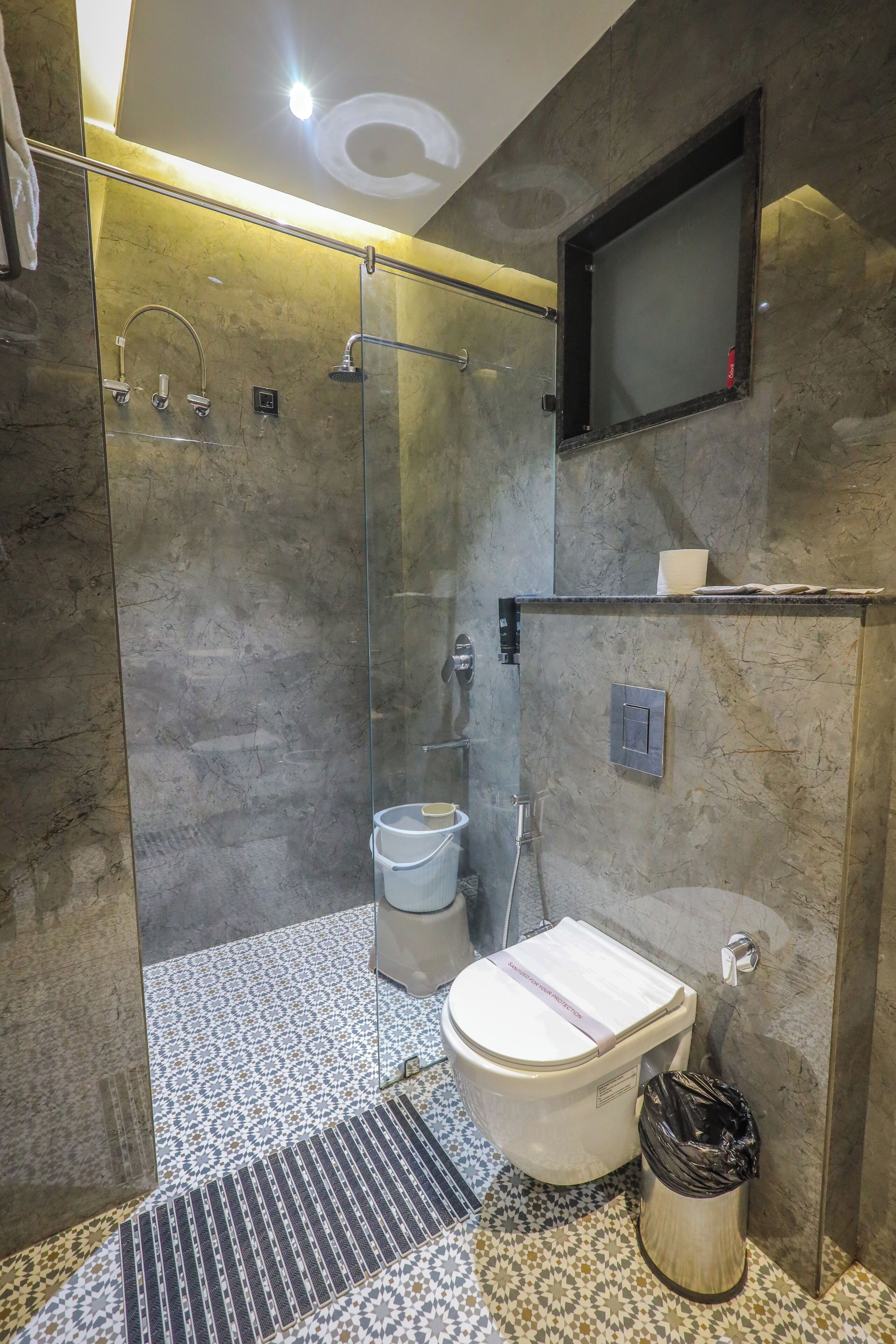 Een moderne badkamer met een glazen douchecabine, een toilet en een wastafel.