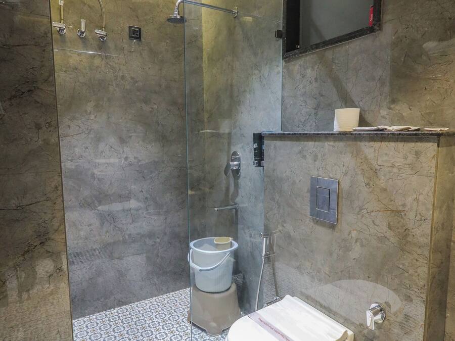 Een moderne badkamer met een glazen douchecabine, een toilet en een wastafel.