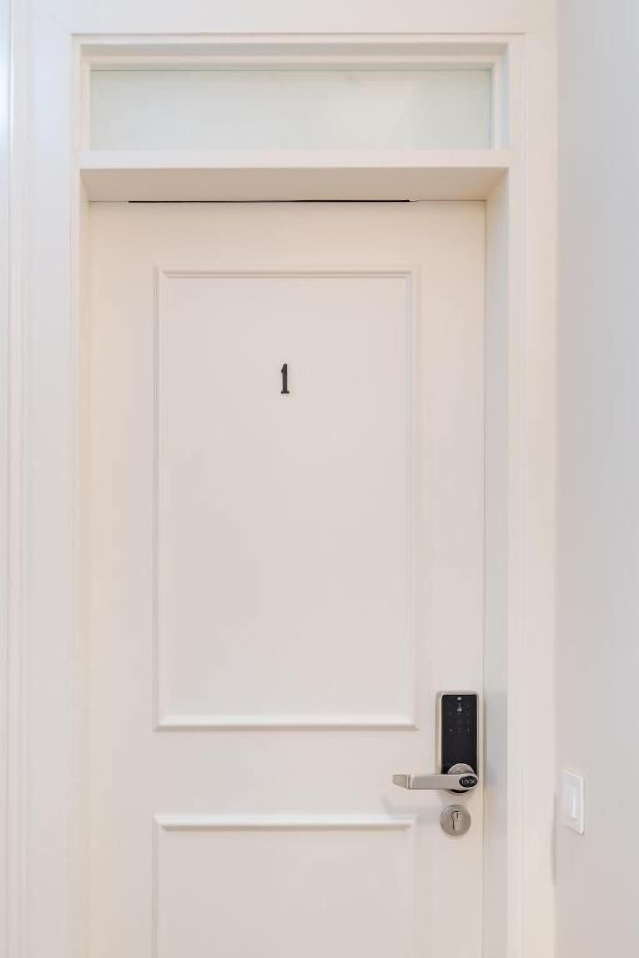 A white door with a numeric keypad lock and a handle.