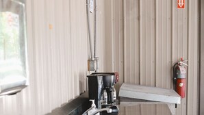 Un comptoir en acier inoxydable équipé d’une machine à café et d’un extincteur fixé au mur.