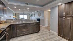 A spacious kitchen with dark wooden cabinets, a granite countertop, and a large island.