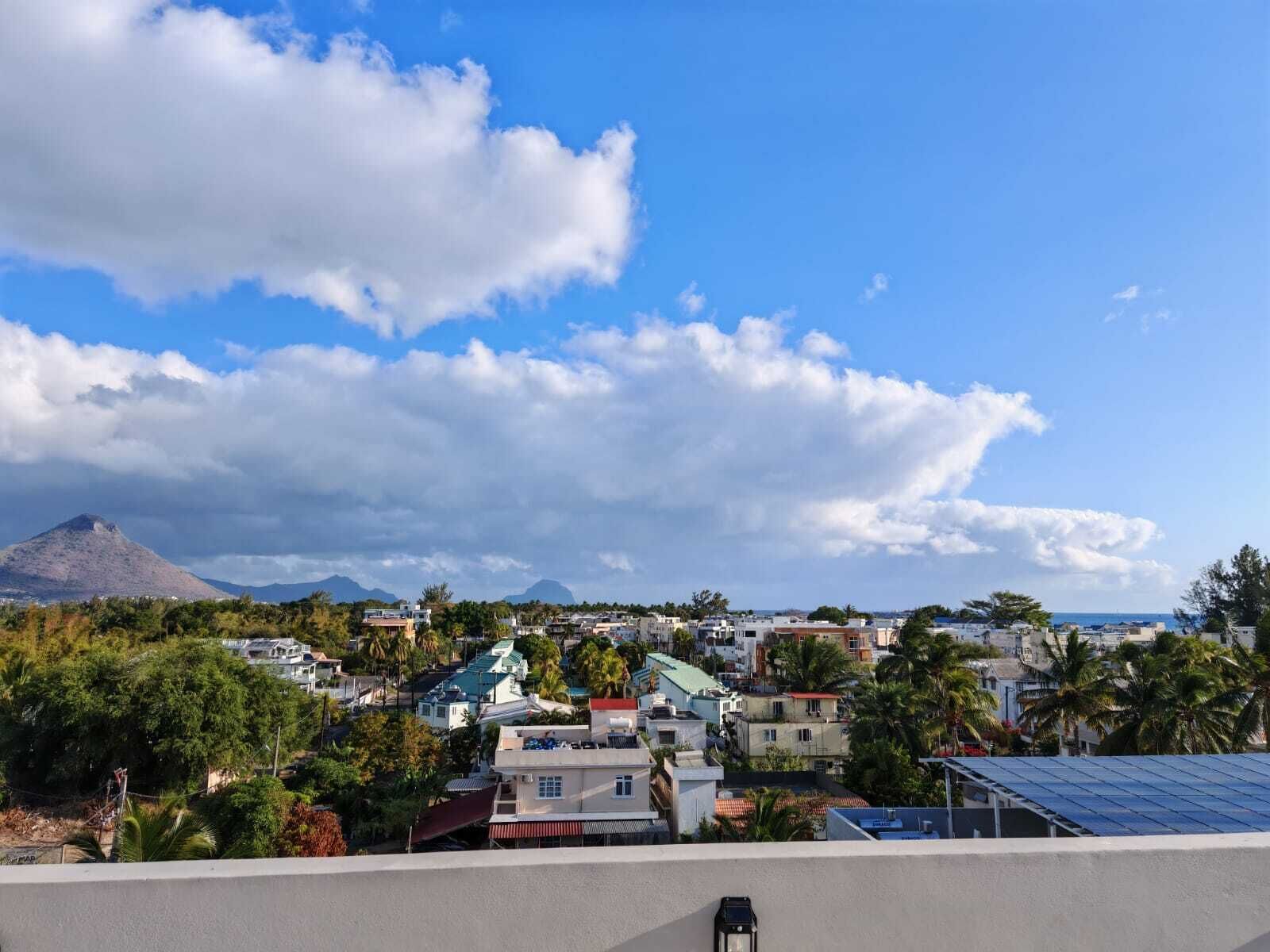 Un quartier résidentiel avec des maisons, une montagne et un ciel dégagé.
