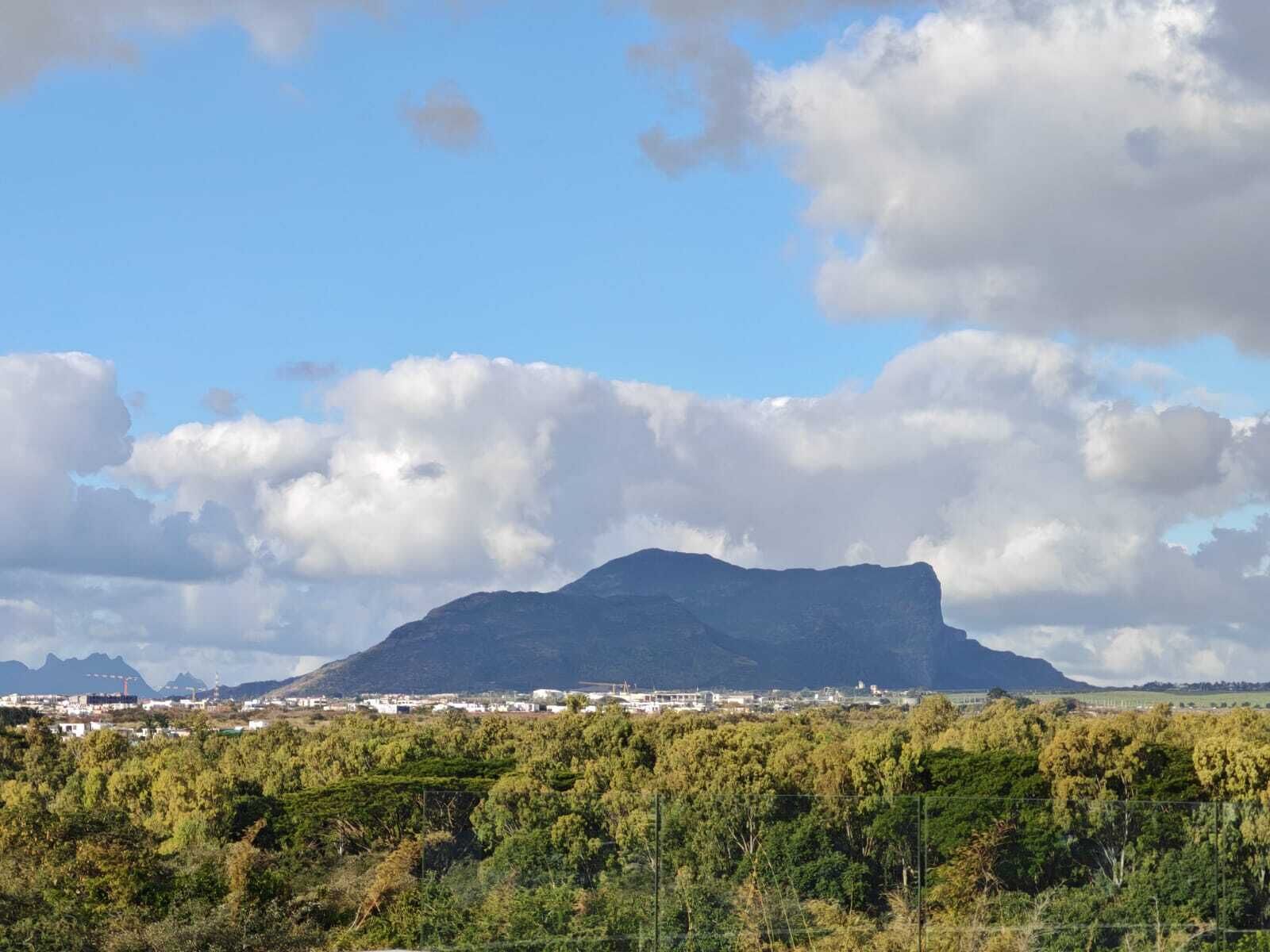 A mountain landscape with a town in the foreground and a clear sky.