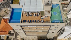 An aerial view of a rooftop with a swimming pool, sun loungers, and a basketball court. - Condo. w/ Pool and Gym 70 m From the Beach - SMA (Salvador)