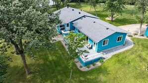 Een tweelaags huis met een overdekte patio, een garage en een gazon.
