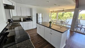 Una cucina moderna con pensili bianchi, un piano di lavoro in granito e un piano cottura integrato.