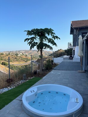 A hot tub in a backyard with a view of a hilly landscape. - El Refugio de Lomas del Flamenco (Mijas)