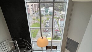 Un intérieur moderne avec une grande fenêtre, un escalier et un luminaire suspendu.