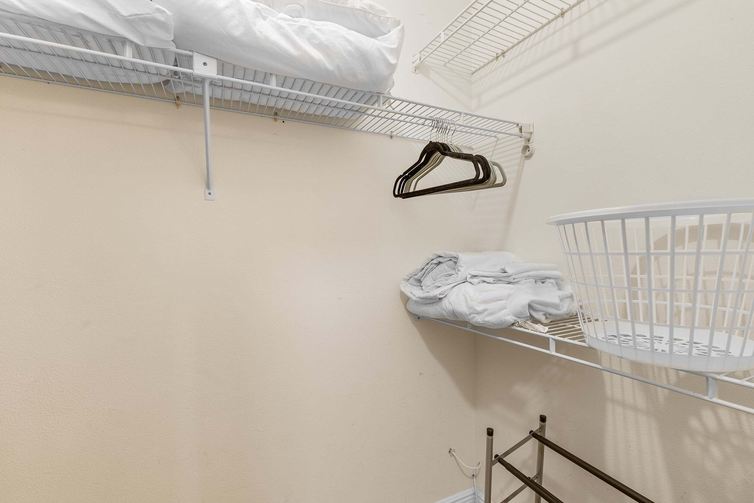 Ein Zimmer mit einem Etagenbett, einem weißen Babybett und einem Metallregal.