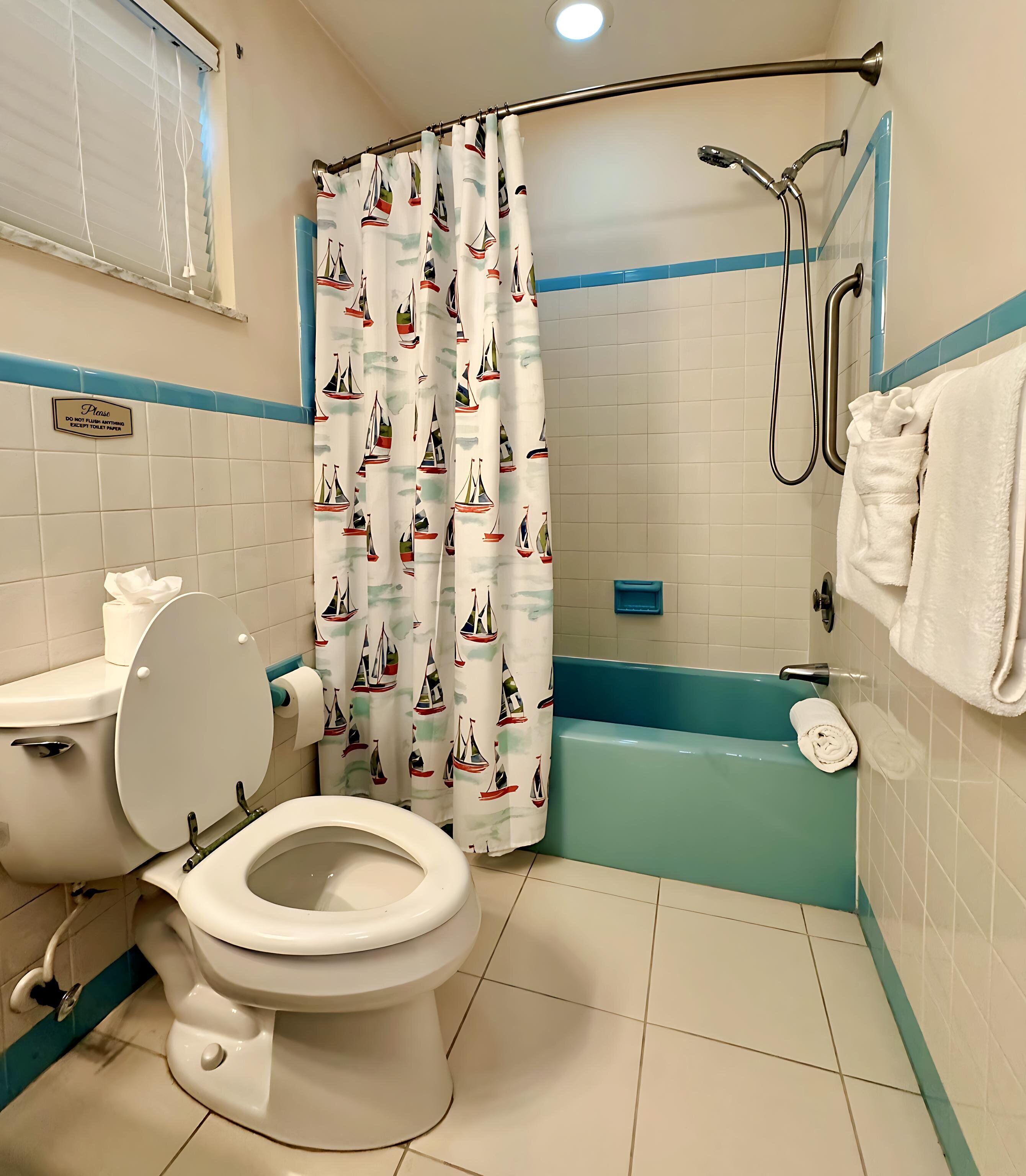 A bathroom with a toilet, a bathtub, and a shower.