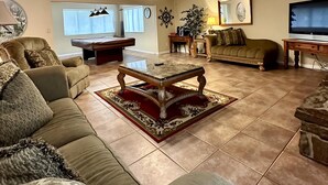 Ein geräumiges Wohnzimmer mit einer Couch, einem Couchtisch und einem Fernseher.