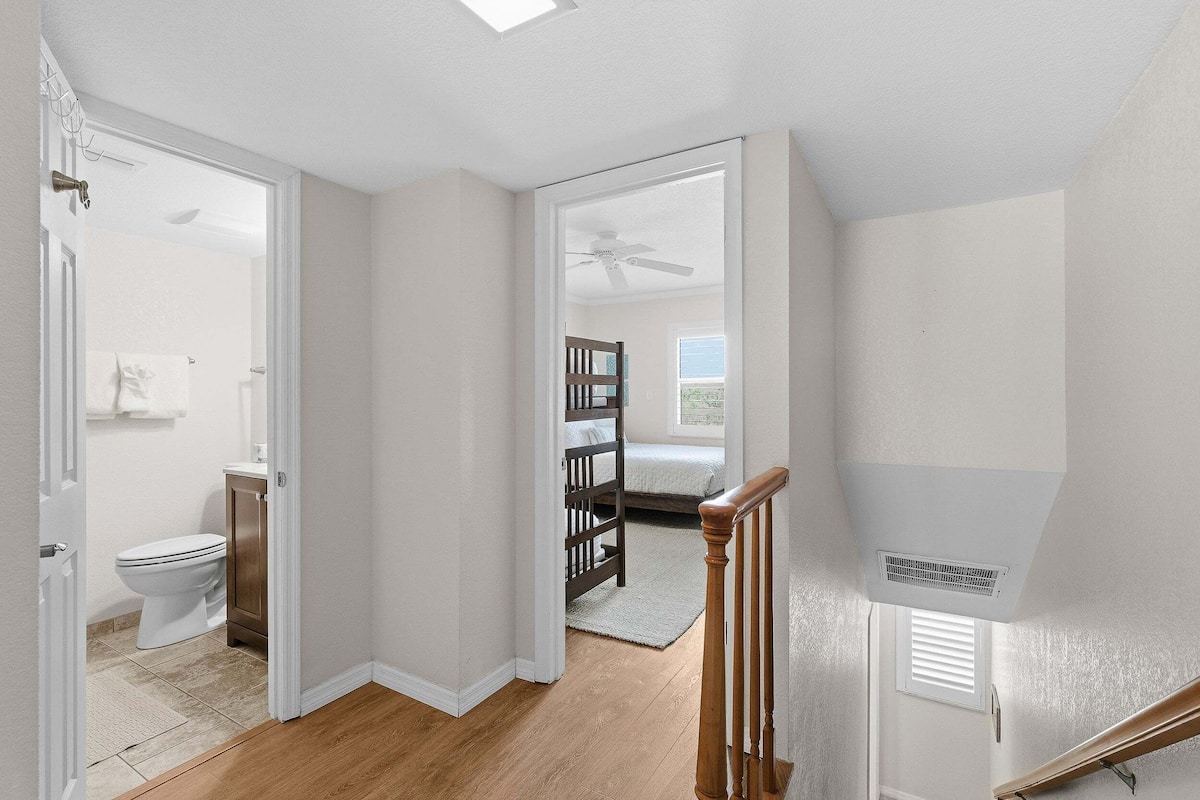 Une chambre à coucher avec un lit, une fenêtre et un ventilateur de plafond.