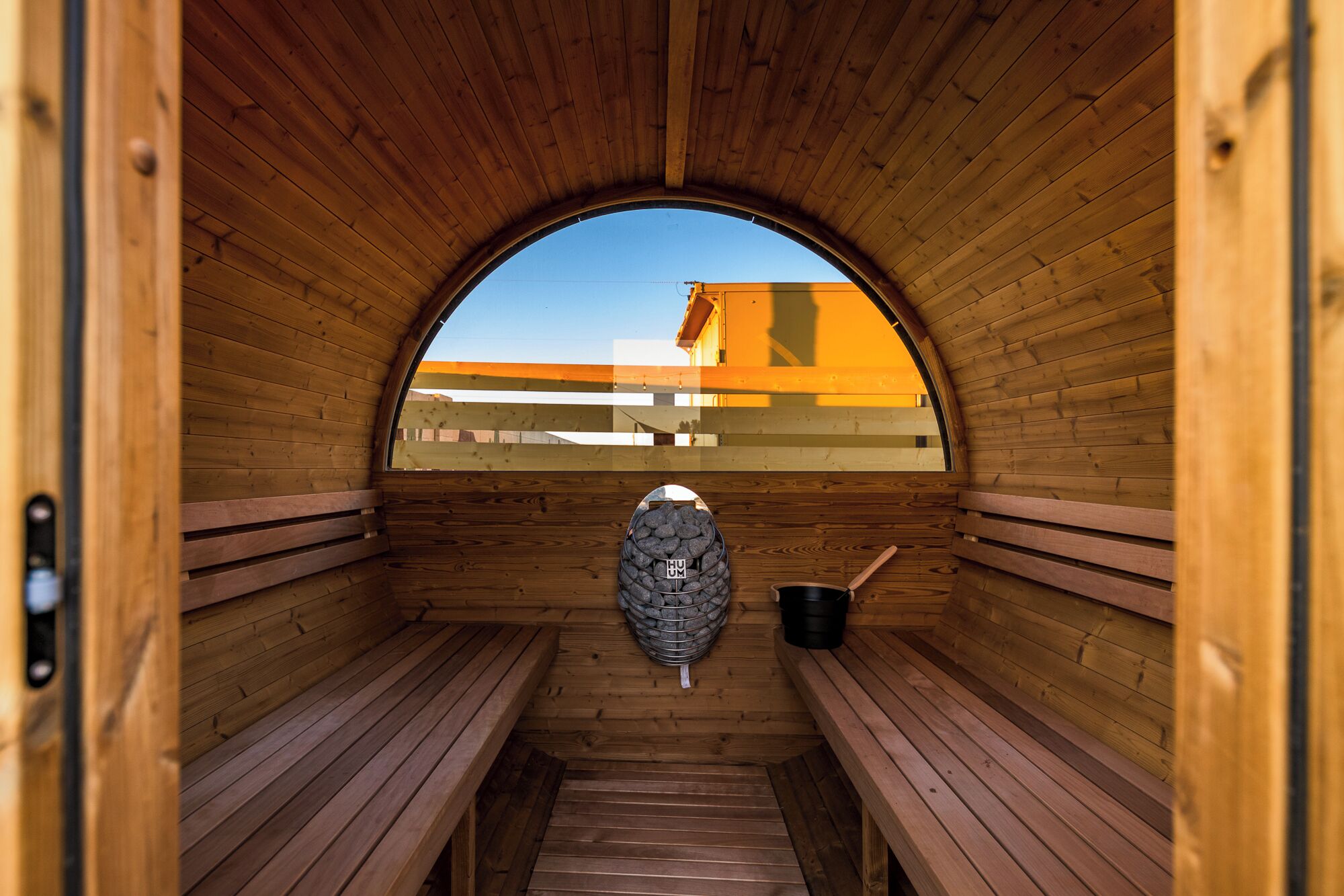 Een sauna met houten banken en een stenen muur.