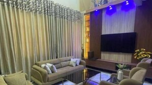A modern living room with a sofa, armchairs, a coffee table, and a TV. - KUMASI's SECRET II (Juahaw)
