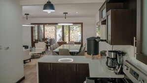 Uma cozinha moderna com ilha central, armários de madeira escura e uma cafeteira.