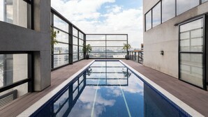A rooftop swimming pool with clear views of the city skyline. - Urbano Duplex by WECARE Hosting (São Paulo)