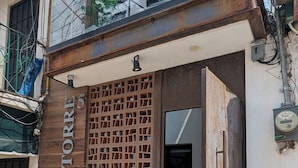 Entrada de un edificio con puerta de madera y portón de metal.