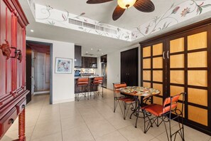 Une cuisine spacieuse dotée d’appareils électroménagers modernes, un coin repas avec une table ronde et des chaises, et un ventilateur de plafond décoratif.