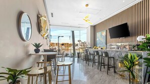A modern bar area with a view of the marina, marble flooring, and contemporary furniture. - Marina Vallarta with View and Pool (Puerto Vallarta)