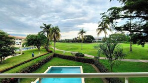 Ein Poolbereich mit Blick auf einen Golfplatz und umliegendes Grün.