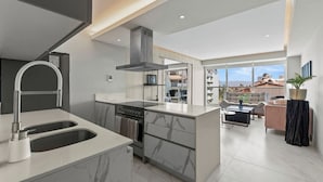 Une cuisine moderne dotée d’un évier à deux bacs, d’une cuisinière et d’un grand îlot central.