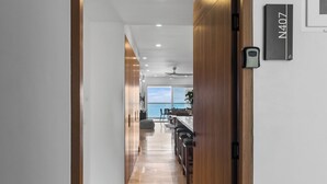 Una cocina moderna con barra, vista al mar y una puerta de madera con la leyenda N407.