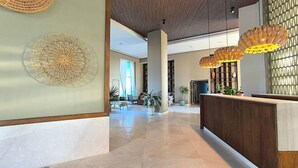 Un vestíbulo moderno con mostrador de recepción, arte decorativo en la pared y techo con diseño.