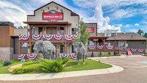 Een gebouw met een bord voor Buffalo Bill's Tavern, met een grote buffelbeeld en Amerikaanse vlagdecoraties.