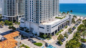 A high-rise hotel with multiple floors, a swimming pool, and a view of the ocean. - Birch Road Beach House | Oceanfront | Luxury Villa (Fort Lauderdale)