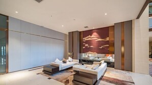 A modern living room with a large wall mural, two sofas, a coffee table, and a side table.