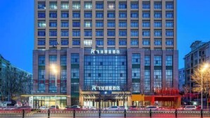 A high-rise hotel with multiple floors, a prominent entrance, and a parking area in front.