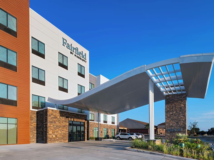 A Marriott hotel with a modern design, featuring a covered entrance and a parking area.
