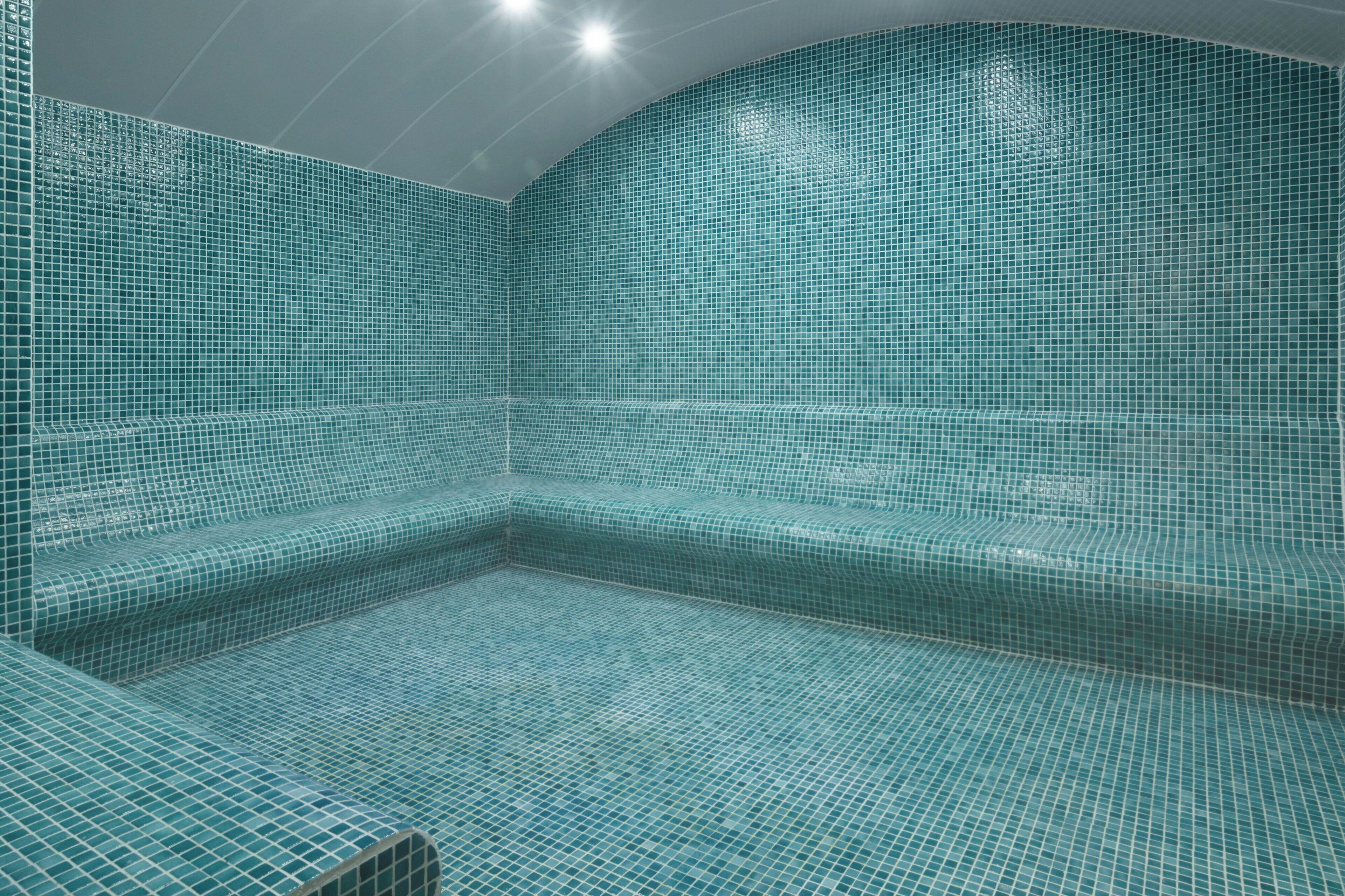 Una piscina moderna y vacía con un diseño geométrico de azulejos.