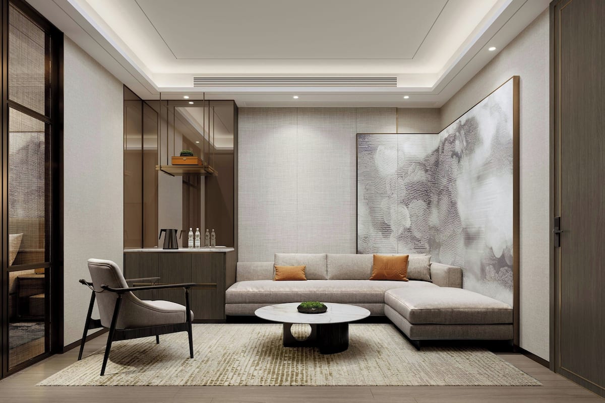 A modern living room with a sectional sofa, a round coffee table, and a chair.