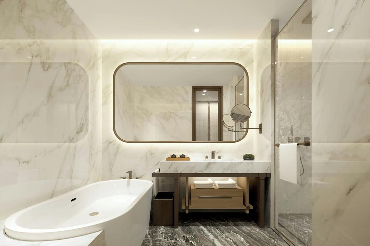A modern bathroom with a freestanding bathtub, a marble vanity, and a large mirror.
