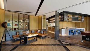 A modern interior with a seating area, a bar, and a kitchen.