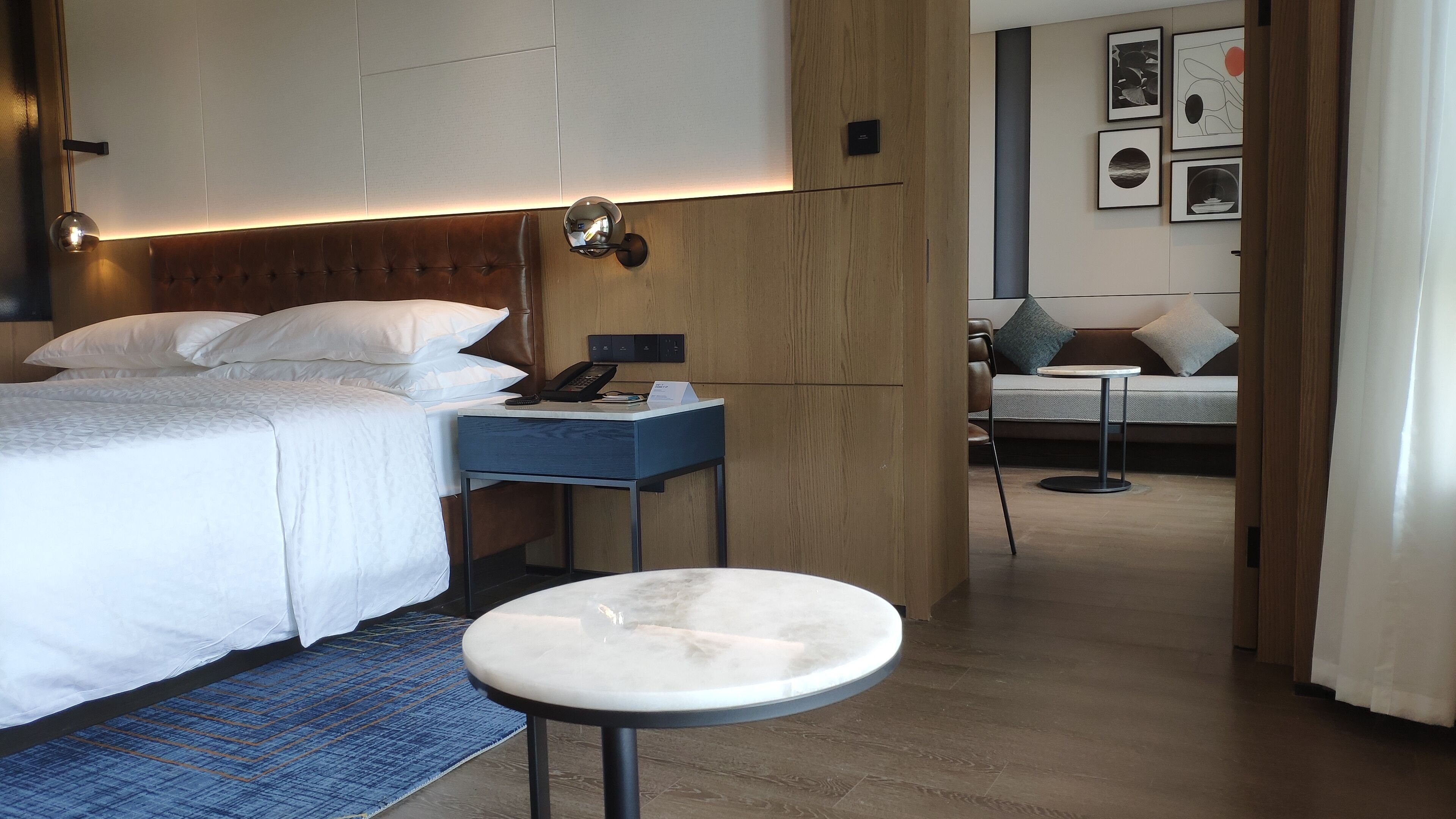 Una habitación de hotel con cama, mesita de noche y una mesa redonda.