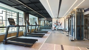 A gym with treadmills, weight machines, and dumbbells.