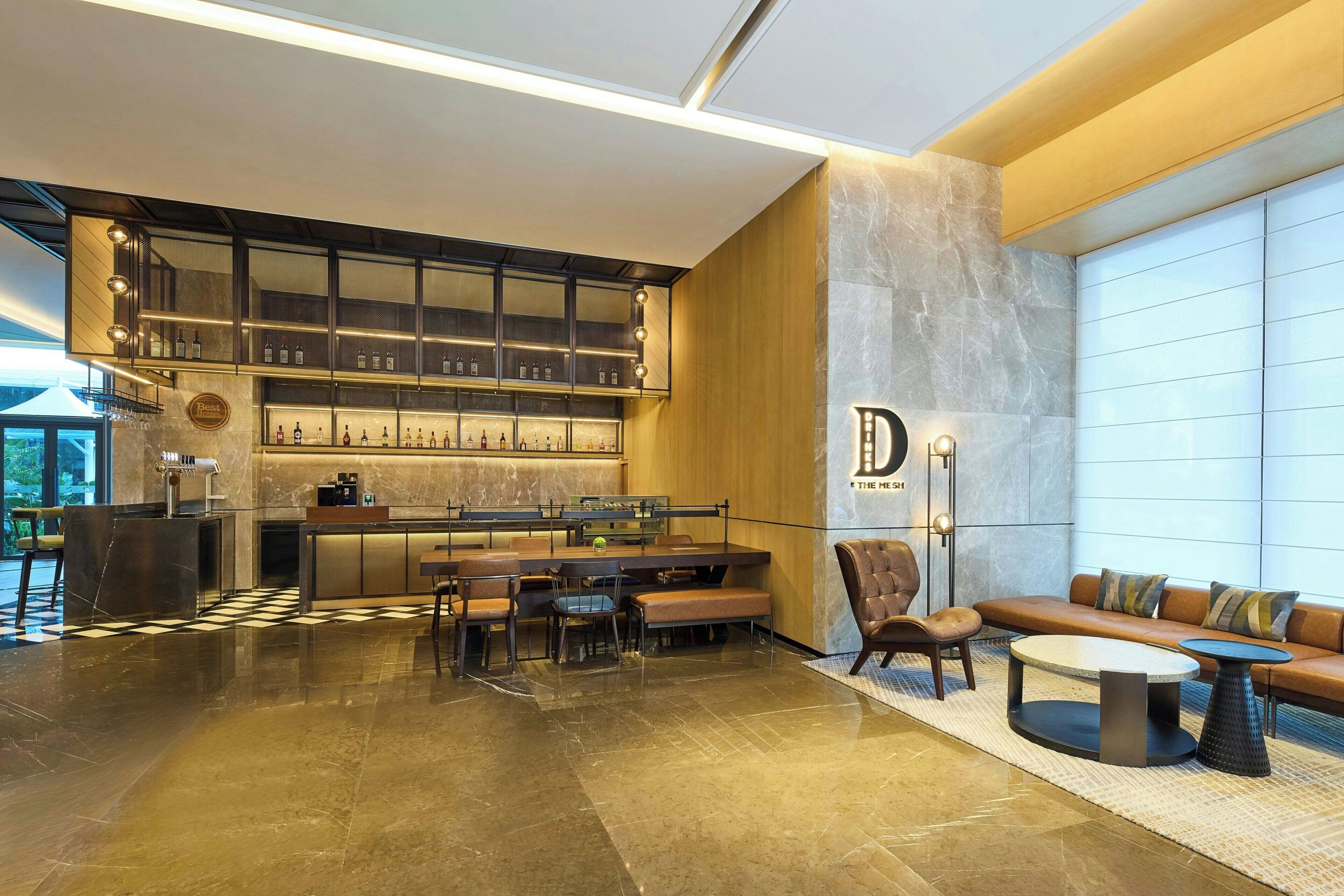 A modern hotel lobby with a bar area, seating arrangements, and a large window providing natural light.