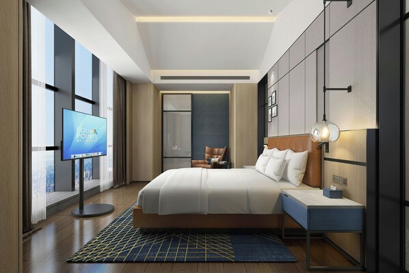 Habitación de hotel moderna con una cama grande, una mesita de noche, un televisor y vistas a la ciudad.