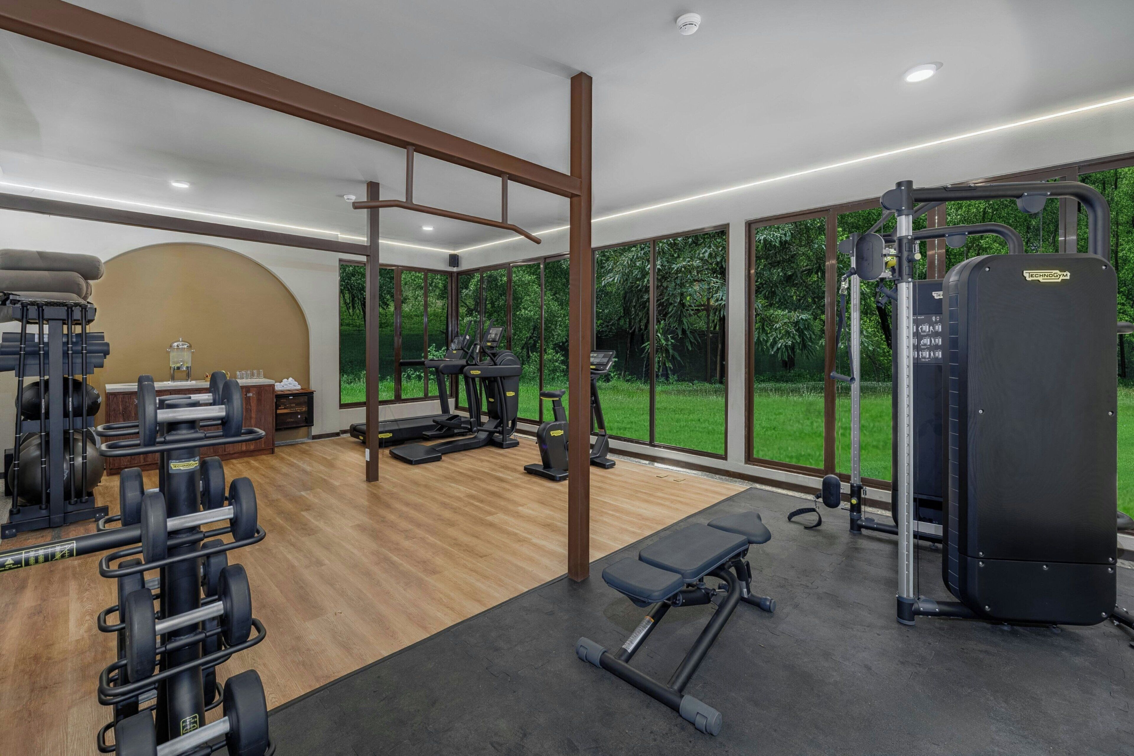 Una palestra moderna con attrezzature cardio, macchinari per sollevamento pesi e una panca.